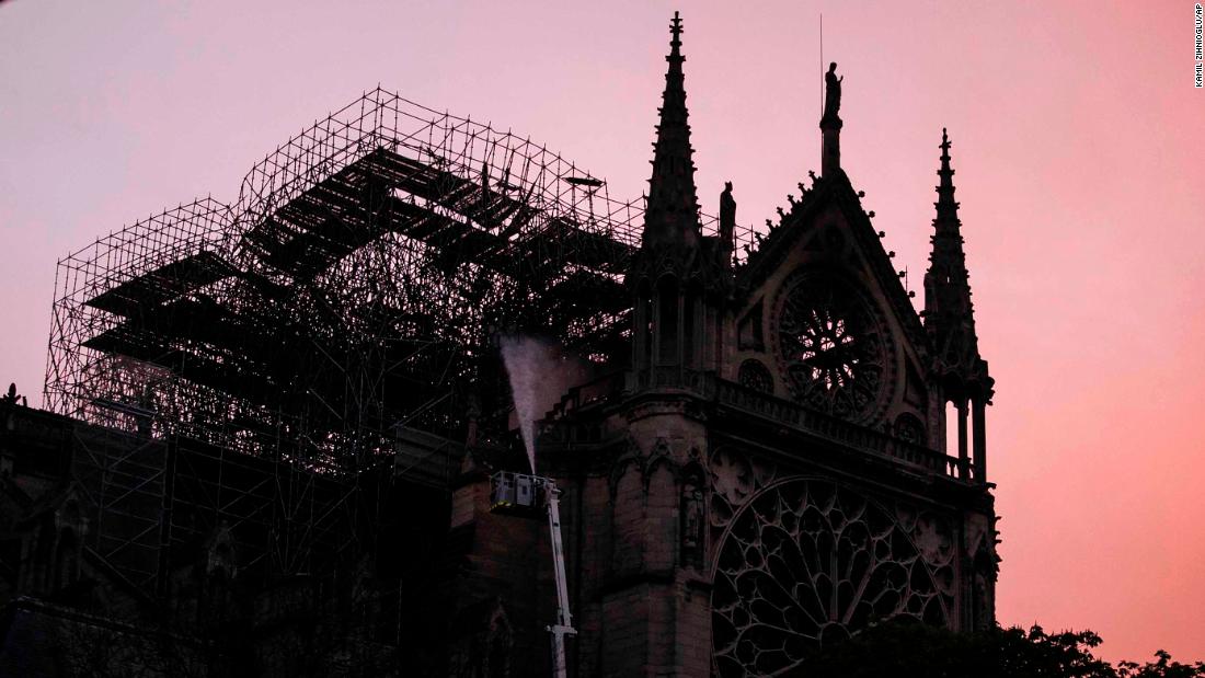 Notre Dame is seen at sunrise as firefighters continue to work at the cathedral on the morning of April 16.