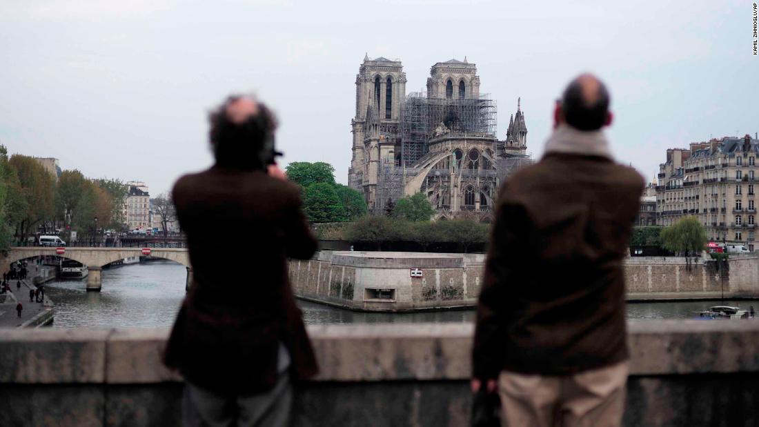 People stop to view Notre Dame Cathedral on the morning following the fire.