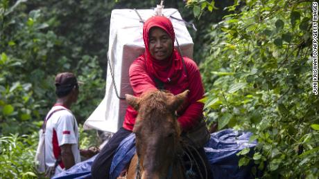 An Indonesian election worker on horseback transports ballot boxes and election material to a remote village in Jember, East Java on April 15, 2019. 