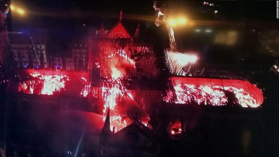 A handout image photographed on a television screen shows an aerial view of Notre Dame Cathedral engulfed in flames on Monday, April 15, 2019.