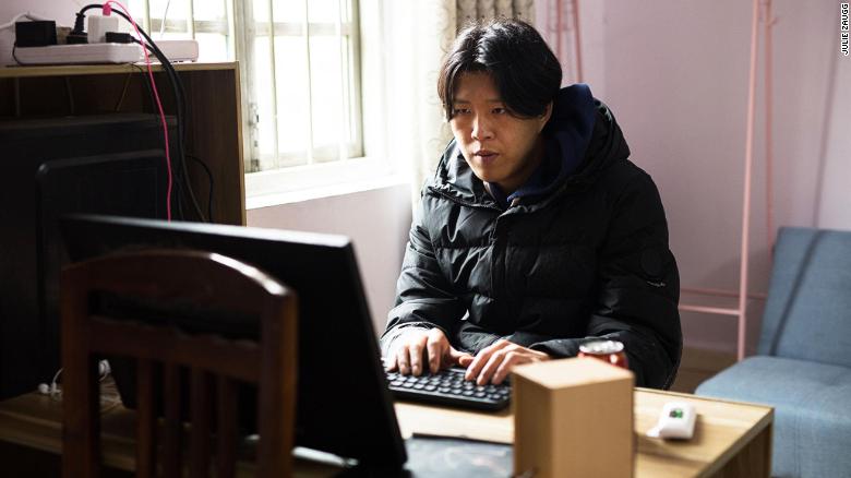 To edit his videos, Wu Nengji uses a old computer with a screen that has no stand and is propped up against a chair.
