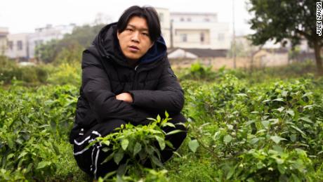 Wu Nengji poses on the rural pig farm from where he streams mini movies across China. 