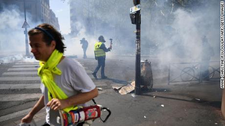 Protesters take cover from tear gas during an anti-government demonstration called by the &quot;Yellow Vests&quot; 