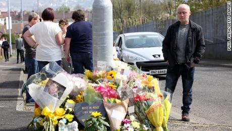 People gather around the floral tributes placed at the site of the killing in the Creggan area of Londonderry in Northern Ireland on Saturday.