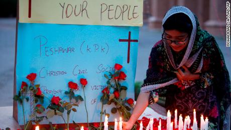 A Christian woman lights a candle at a vigil for the for the victims of bomb explosions in churches and hotels in Sri Lanka, in Peshawar, Pakistan, Sunday, April 21, 2019. (AP Photo/Mohammad Sajjad)