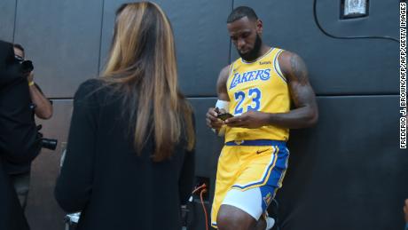 LA Lakers&#39; LeBron James checks his cellphone ahead of a press conference