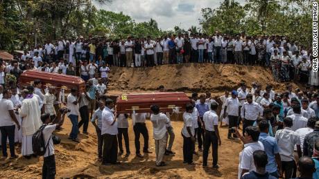 NEGOMBO, SRI LANKA - APRIL 23: Coffins are carried to a grave during a mass funeral at St Sebastian Church on April 23, 2019 in Negombo, Sri Lanka. At least 311 people were killed with hundreds more injured after coordinated attacks on churches and hotels on Easter Sunday rocked three churches and three luxury hotels in and around Colombo as well as at Batticaloa in Sri Lanka. Sri Lankan authorities declared a state of emergency on Monday as police arrested 24 people so far in connection with the suicide bombs, which injured at least 500 people as the blasts took place at churches in Colombo city as well as neighboring towns and hotels, including the Shangri-La, Kingsbury and Cinnamon Grand. (Photo by Carl Court/Getty Images)