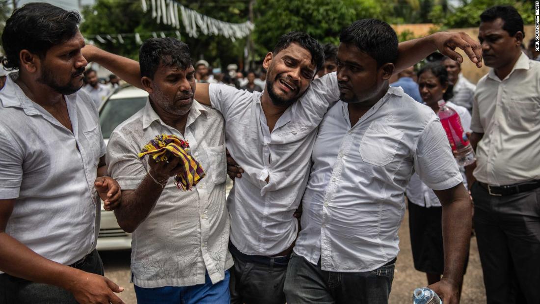 A man is supported as he follows a coffin during a mass funeral for bombing victims at St. Sebastian Church in Negombo, Sri Lanka, on Tuesday, April 23.