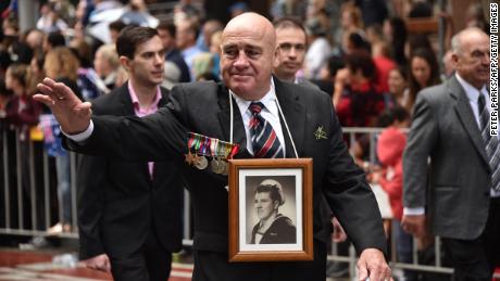 The relative of a fallen serviceman waves to crowds during the Anzac Day parade in Sydney on April 25, 2018.