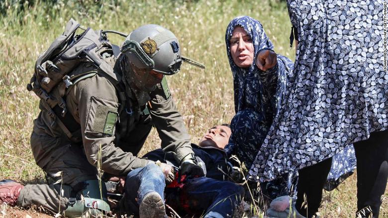 An Israeli soldier performs first aid on al-Badan.