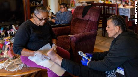 Patricia Zamora&#39;s grandmother helps clean her wound. Zamora had to stop working, was evicted and eventually moved into her grandmother&#39;s house.