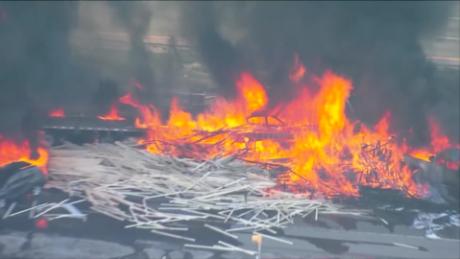 Video from the scene showed towering orange flames and piles of lumberscattered across the highway. 