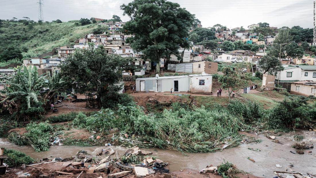 People abandon their homes at an informal settlement of BottleBrush, south of Durban, after torrential rains and flash floods destroyed their homes on April 23, 2019. - The death toll from floods and mudslides that crushed homes in the South African port of Durban on April 23 has risen to 33, with reports of children missing and scores of people displaced, authorities said. 