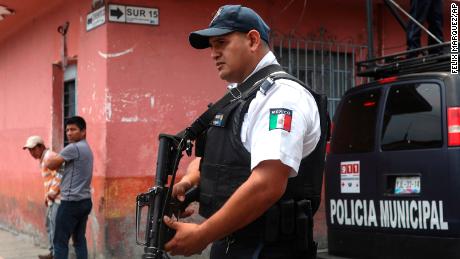 Municipal police stand guard on the corner of the street where the forensic office is located, where the bodies of Mixtla de Altamirano Mayor Maricela Vallejo, her husband and her driver were taken in Orizaba, Veracruz, Mexico, Thursday, April 25, 2019. Prosecutors said the three came under fire from behind and both sides of their SUV while traveling on a highway. (AP Photo/Felix Marquez)