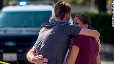 People embrace outside the Congregation Chabad synagogue.