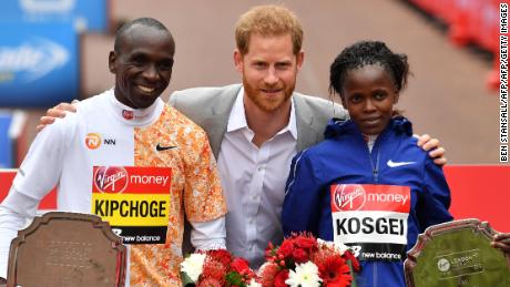 Britain&#39;s Prince Harry, Duke of Sussex, is flanked by men&#39;s race winner Kenya&#39;s Eliud Kipchoge (L) and women&#39;s race winner, Kenya&#39;s Brigid Kosgei (R) at the medal ceremony at the 2019 London Marathon.