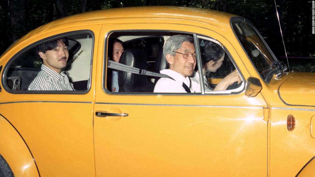 Akihito drives to an imperial villa in 1989. Michiko is in the front passenger seat. Behind Akihito is his son Fumihito.