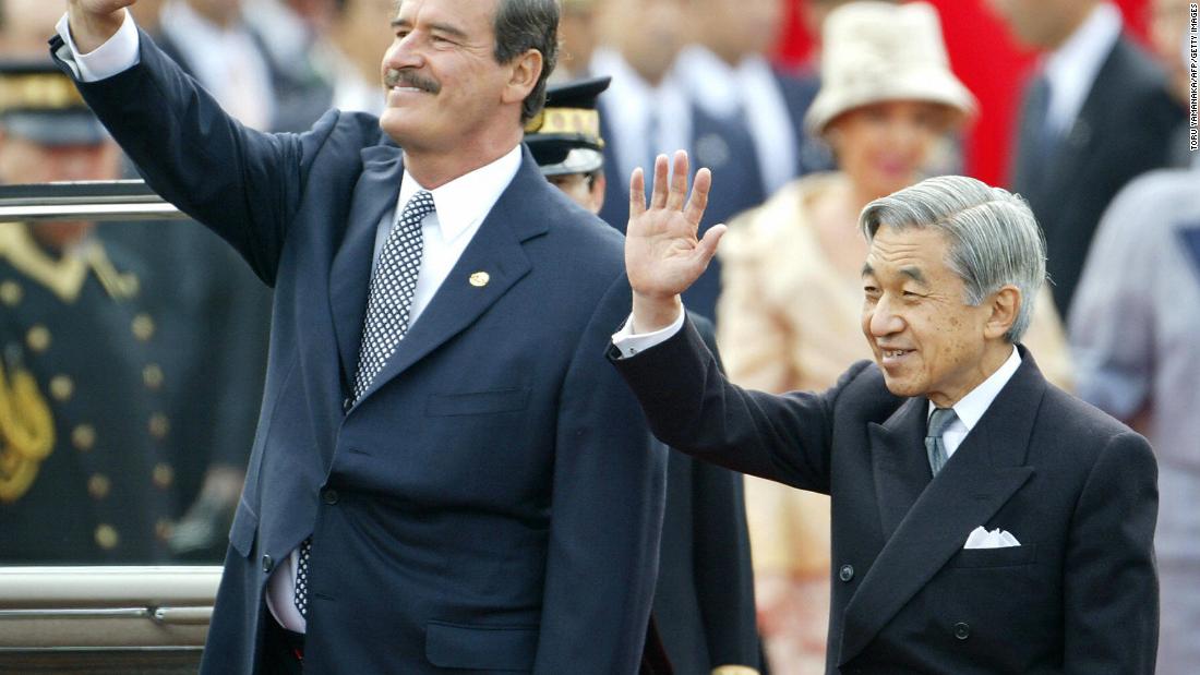 Akihito and Mexican President Vicente Fox wave to people while Fox visited Tokyo in 2003.