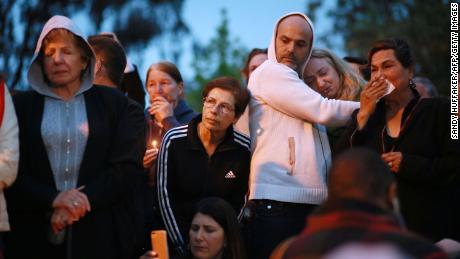 Community members and congregants attend a candlelight vigil Sunday night.