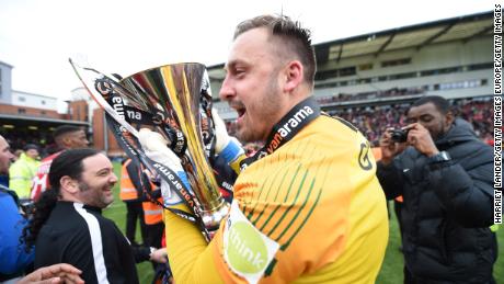 Goalkeeper Dean Brill of Leyton Orient celebrates with the National League trophy.