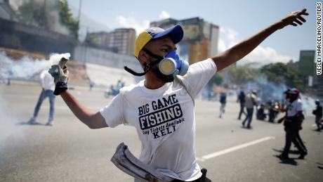 An opposition demonstrator throws back a tear gas canister on a street near the Generalisimo Francisco de Miranda Airbase "La Carlota" in Caracas, Venezuela April 30, 2019. REUTERS/Ueslei Marcelino