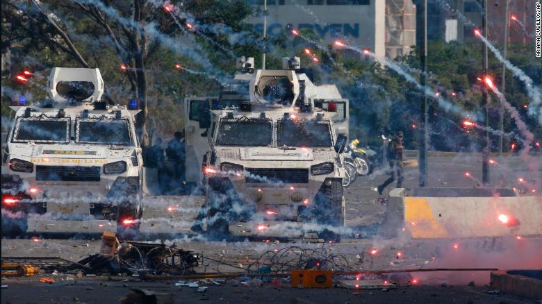 Fireworks launched by opponents of Venezuela&#39;s President Nicolas Maduro land near Bolivarian National Guard armored vehicles loyal to Maduro, during an attempted military uprising in Caracas, Venezuela, Tuesday, April 30, 2019. Opposition leader Juan Guaido took to the streets with a small contingent of heavily armed troops in a call for the military to rise up. (AP Photo/Ariana Cubillos)