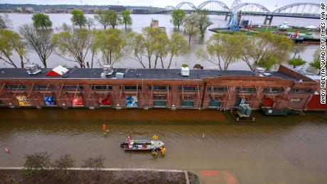 Davenport firefighters walk a rescue boat down West River Drive along the freight house in Davenport on Tuesday, April 30, 2019.