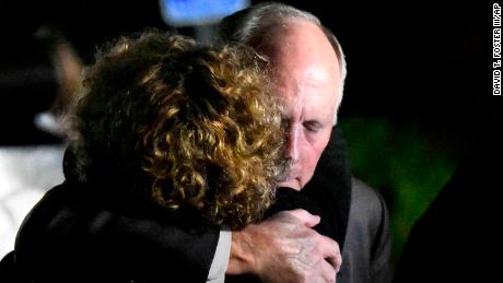 UNC Charlotte Chancellor Philip Dubois receives a hug after a news conference on the deadly shooting.