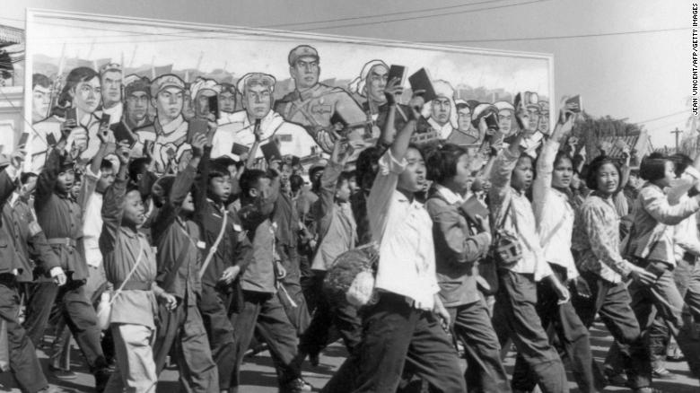 Red Guards, high school and university students waving copies of Chairman Mao Zedong&#39;s &quot;Little Red Book,&quot; parade through the streets of Beijing in June 1966 during the Cultural Revolution.