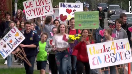 Students carrying signs and flowers walked together to Davidson&#39;s home, stood on her lawn and blew her a collective kiss. 