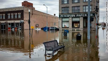 Floodwaters surround a bench near the main breach in the Mississippi River in Davenport, Iowa, on Friday, May 3, 2019.