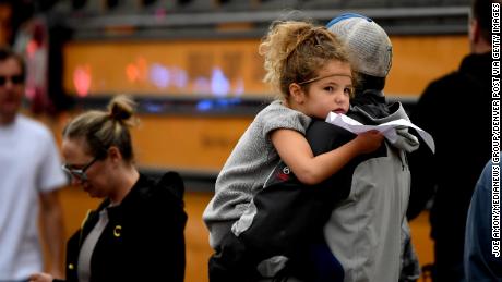 A child is held while waiting to get on their evacuation buses after a shooting at the STEM School Highlands Ranch on May 7.