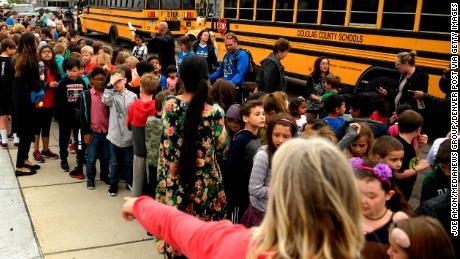 Officers and teachers evacuating students after a shooting at the STEM School Highlands Ranch.