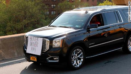 Uber and Lyft drivers, with signs on their vehicles supporting better wages, cross the Brooklyn Bridge in a caravan of about 25 vehicles, Wednesday, May 8, 2019 in New York. The protests arrive just ahead of Uber&#39;s initial public stock offering, which is planned for Friday.  (AP Photo/Mark Lennihan)