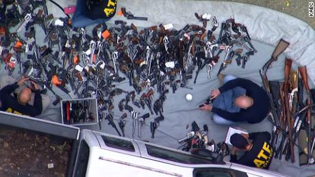 Officers take inventory of guns outside a home in the Holmby Hills section of Los Angeles.