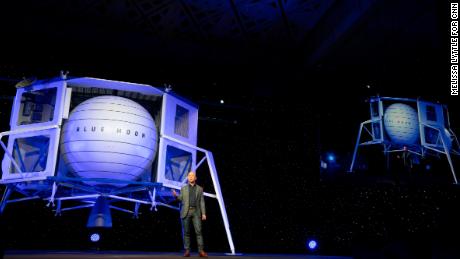 Jeff Bezos stands in front of a Blue Origin prototype of a lunar lander named Blue Moon.