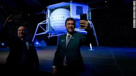 Attendees take selfies in front of the Blue Moon lunar lander after the presentation.