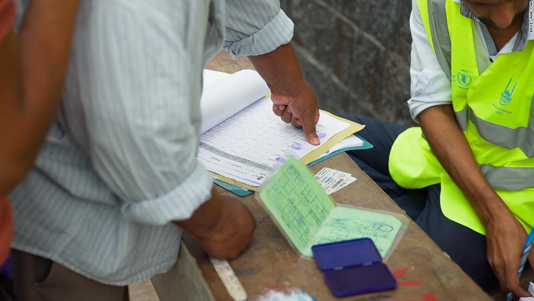 Aid recipients mark a thumbprint to confirm they have received supplies. 