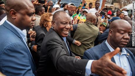 Cyril Ramaphosa greets voters as he arrives to cast his vote.