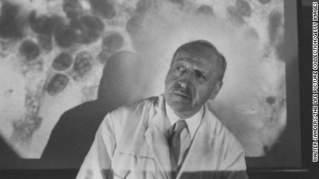 Dr. George Papanicolaou in front of slide of cancer cells at Francis Delafield Hospital. 