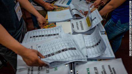 Election workers sort lists of voters at a polling precinct in Manila.