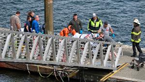 Emergency response crews transport an injured passenger to an ambulance at the George Inlet Lodge docks, Monday, May 13, 2019, in Ketchikan, Alaska. The passenger was from one of two float planes reported down in George Inlet early Monday afternoon and was dropped off by a U.S. Coast Guard 45-foot response boat. (Dustin Safranek/Ketchikan Daily News via AP)