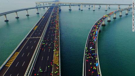 This photo taken on November 19, 2017 shows participants crossing the Jiaozhou Bay Bridge as they compete in the 2017 Qingdao International Marathon over the sea in Qingdao in China&#39;s eastern Shandong province. 