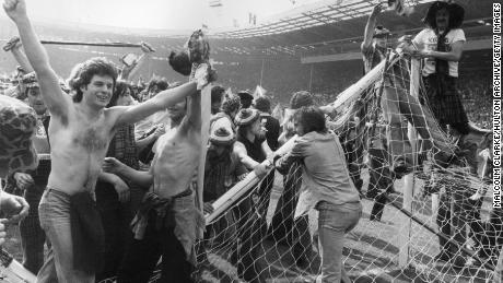 Scottish football fans invading the pitch and pulling down goalposts after Scotland&#39;s men beat England 2-1 at Wembley Stadium in 1977. 