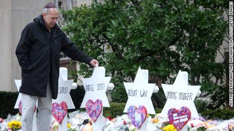 A man walks past memorials in front of the Tree of Life Synagogue after 11 people were shot and killed there in 2018.