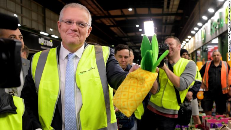 Prime Minister Scott Morrison is given a pineapple hat from a vendor as he visits the Sydney Markets on May 16.