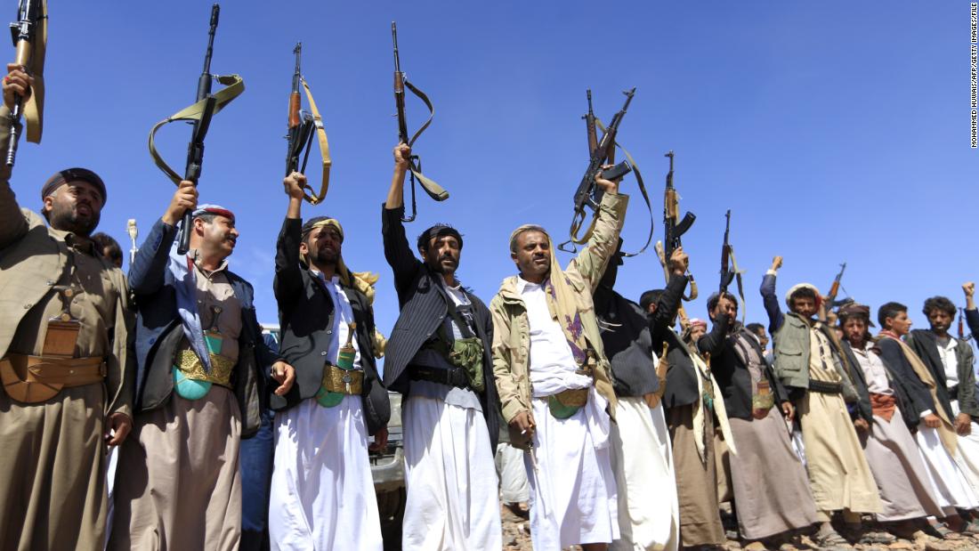 Armed men raise their weapons as they gather near Sanaa to show their support of the Houthi movement in February.