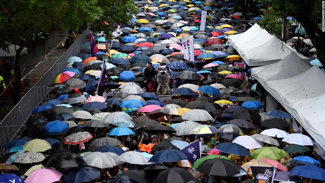 Gay rights supporters wait in the rain outside the parliament building in Taipei before the landmark decision was announced on Friday.