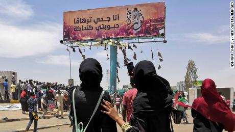 TOPSHOT - A woman takes a photograph with her smarphone of a billboard showing a reproduction of a picture of Alaa Salah, a Sudanese woman who has become an icon of the protest movement after a video of her leading demonstrators&#39; chants went viral, in the capital Khartoum on April 14, 2019. - Sudan&#39;s foreign ministry on today urged the international community to back the country&#39;s new military rulers to help &quot;democratic transition&quot;. (Photo by ASHRAF SHAZLY / AFP)        (Photo credit should read ASHRAF SHAZLY/AFP/Getty Images)