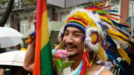 A gay rights supporter holds a flower outside Parliament to support the same sex marriage bill while law makers discusses the same sex marriage bill in Taipei on May 17, 2019. 